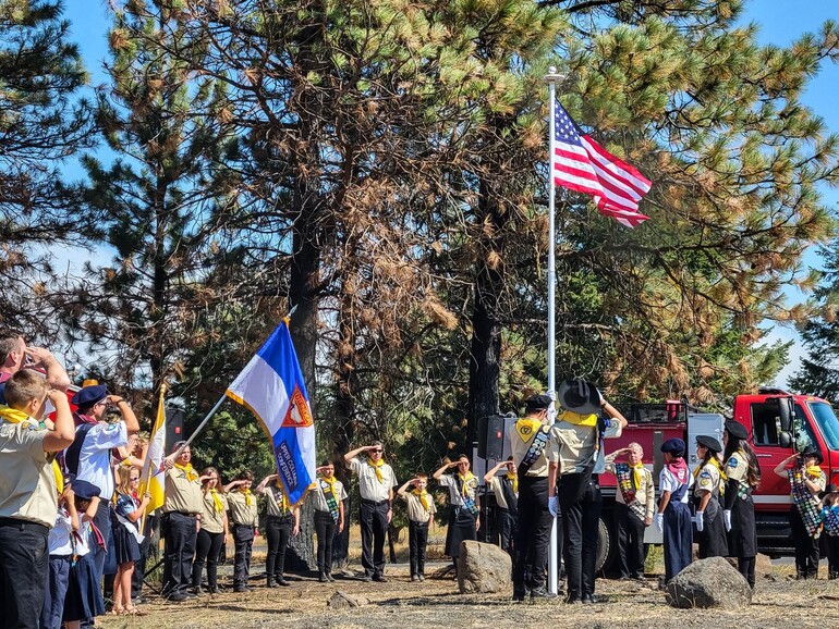 Upper Columbia Academy Pathfinders raise a new flag over the town of Malden, during a ceremony commemorating one year following the widespread destruction from the Babb Road Fire.