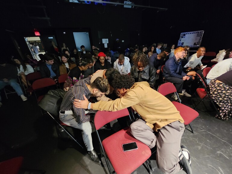 Students pray earnestly for each other during communion service.