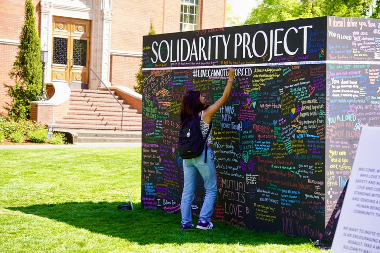 young person writing on wall