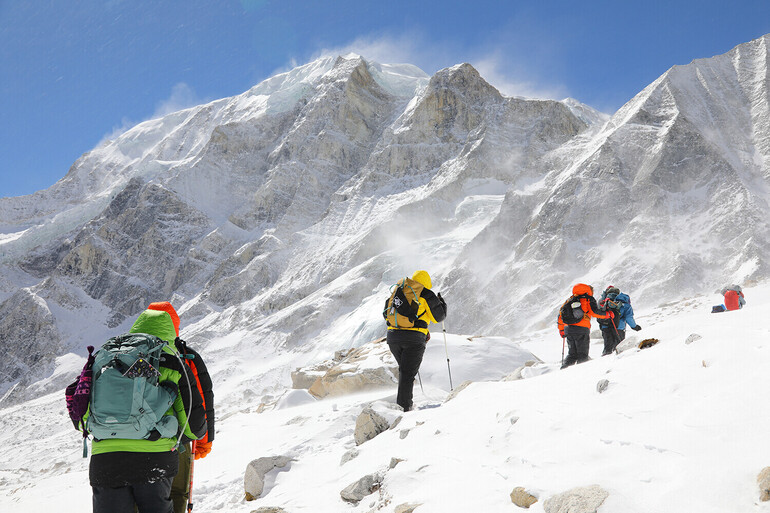 group climbing snowy mountain