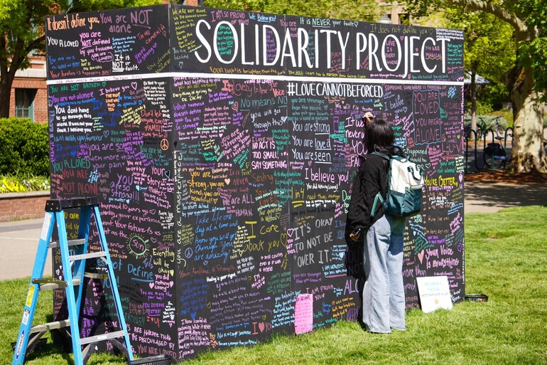 young person writing on wall