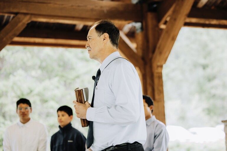 Pastor Steve Rogers speaks outdoors with a bible in his hands