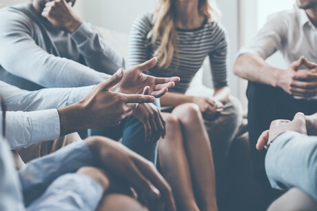 Hands reaching out during group discussion.