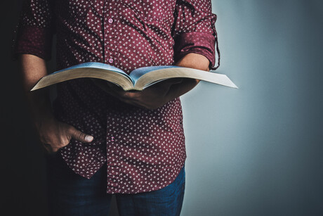 Man holds a Bible.
