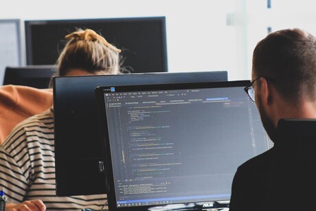 Male and female students write code on computers