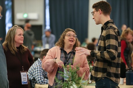 two women and one man talk to each other at an event