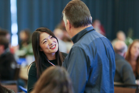 a woman smiles at a man who is talking to her