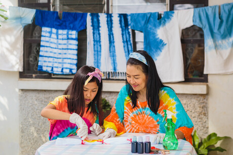 Asian mother and daughter enjoy making tie dye clothes at home