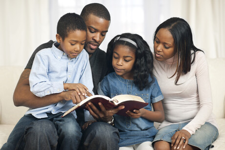 African American family reading the Bible.
