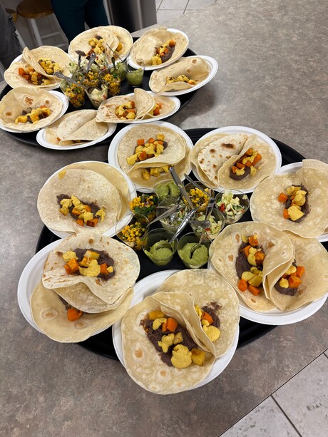 Cooked vegetables wrapped in tortillas form a spread for a table.