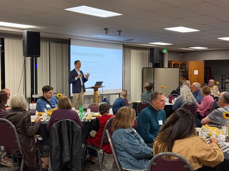 A speaker giving a presentation on mental health to an audience.