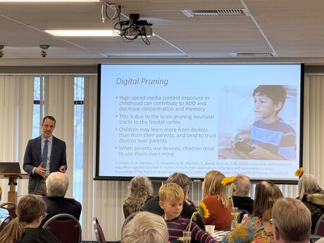 Dr. Daniel Binus, speaking about mental health in young people to an audience of children and adults.