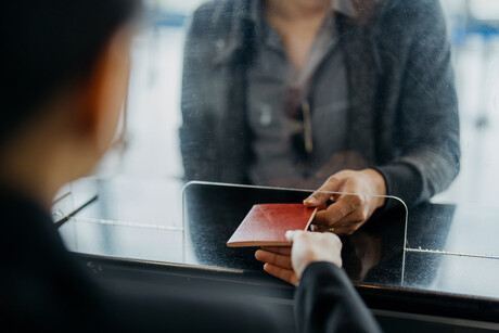 Image of a traveller giving passport to personnel