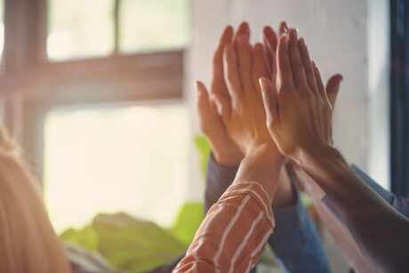 Group of people high fiving. Shot is a close up of hands.