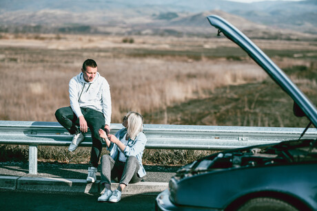 Couple Waiting For Help To Arrive When Car Breaks Down On Highway