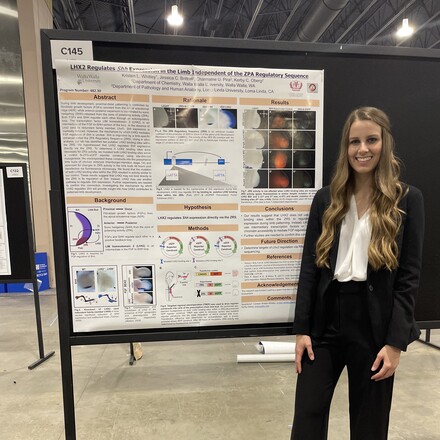 Young woman standing by scientific poster.