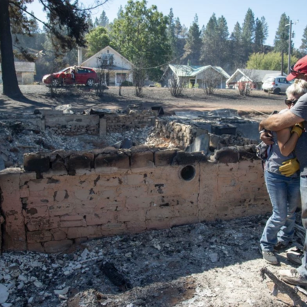 Couple embraces each other after losing their home in the Babb Road Fire.