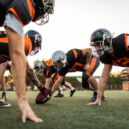 Young Men Playing American Football Game On Sports Training at Stadium