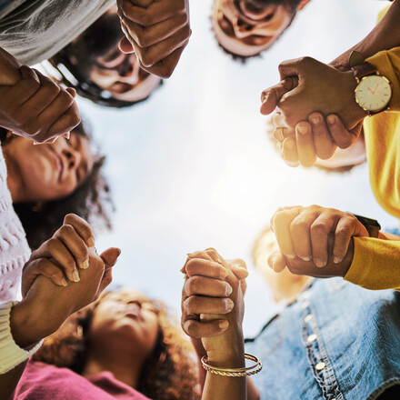 Cropped shot of a group of friends holding hands