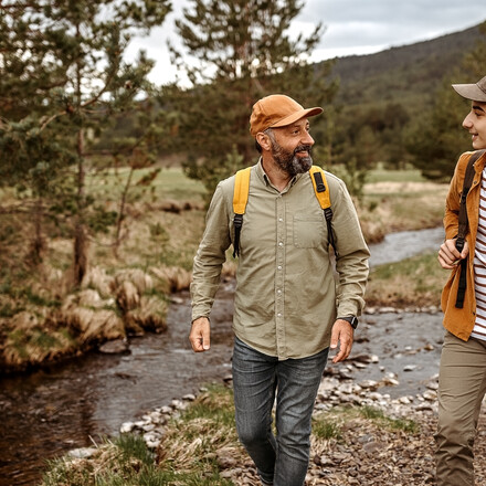 Father and son talking while walking by the river.