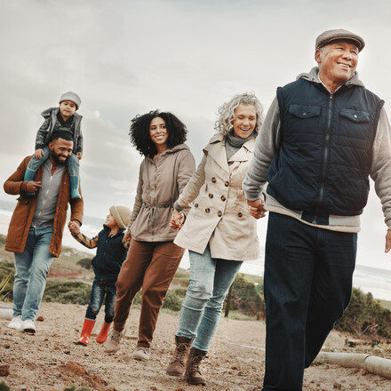 Family holding hands, hiking outdoor together in nature and happiness, bonding and spending quality time. Grandparents, parents and children walking, love and care with happy people and generations