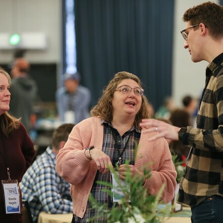 two women and one man talk to each other at an event