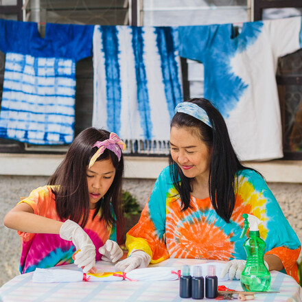 Asian mother and daughter enjoy making tie dye clothes at home