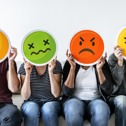 Diverse people holding emoticon