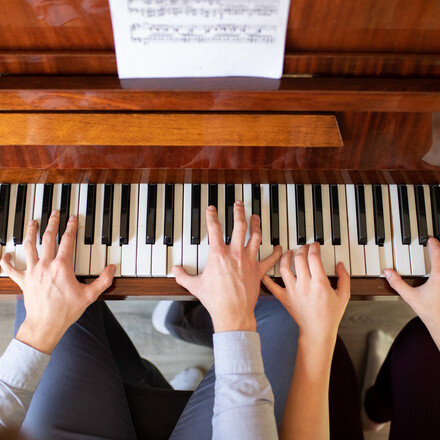 Siblings playing piano together