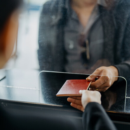 Image of a traveller giving passport to personnel