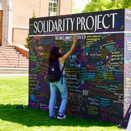 young person writing on wall