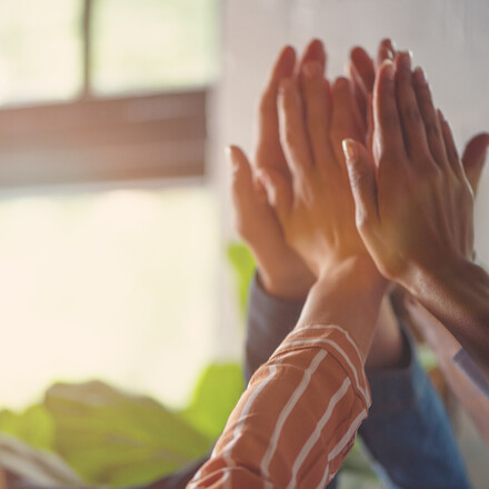 Group of people high fiving. Shot is a close up of hands.