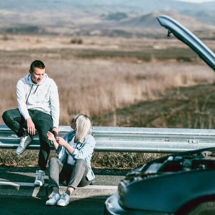 Couple Waiting For Help To Arrive When Car Breaks Down On Highway