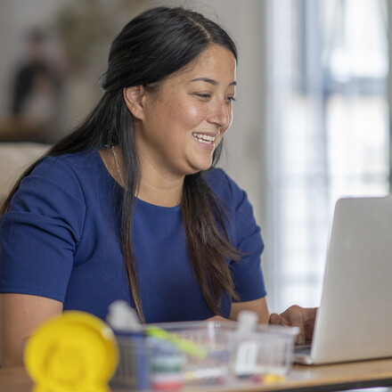 Female teacher working from home, using video chat to connect with her students during the COVID-19 pandemic.