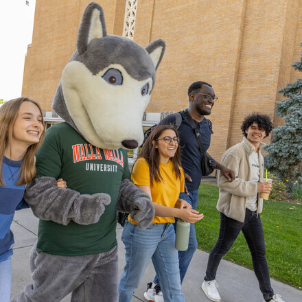 Walla Walla University students and mascot walking and laughing.