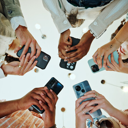 People, circle and phones for university registration, online and teamwork in education on campus. Students, low angle and huddle for project solidarity in college, collaboration and united learning