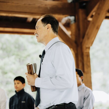 Pastor Steve Rogers speaks outdoors with a bible in his hands