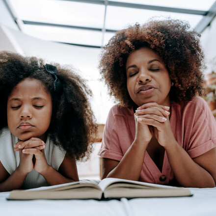Mother teaches daughter to pray