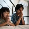 Mother and daughter praying at home