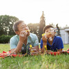 asian old father together with son lie on the grass in the park and blow soap bubbles and rejoice in summer, korean boy rest and play with dad outdoors, concept of parental love and care