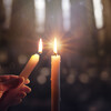 Sharing Concept - Hands Holding Candle With Shining Flame And Blurry Lights