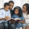 African American family reading the Bible.