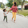 Mom and daughter walking together through the neighborhood.