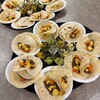 Cooked vegetables wrapped in tortillas form a spread for a table.