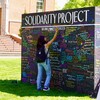 young person writing on wall