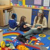 Students reading with the teacher’s aide 