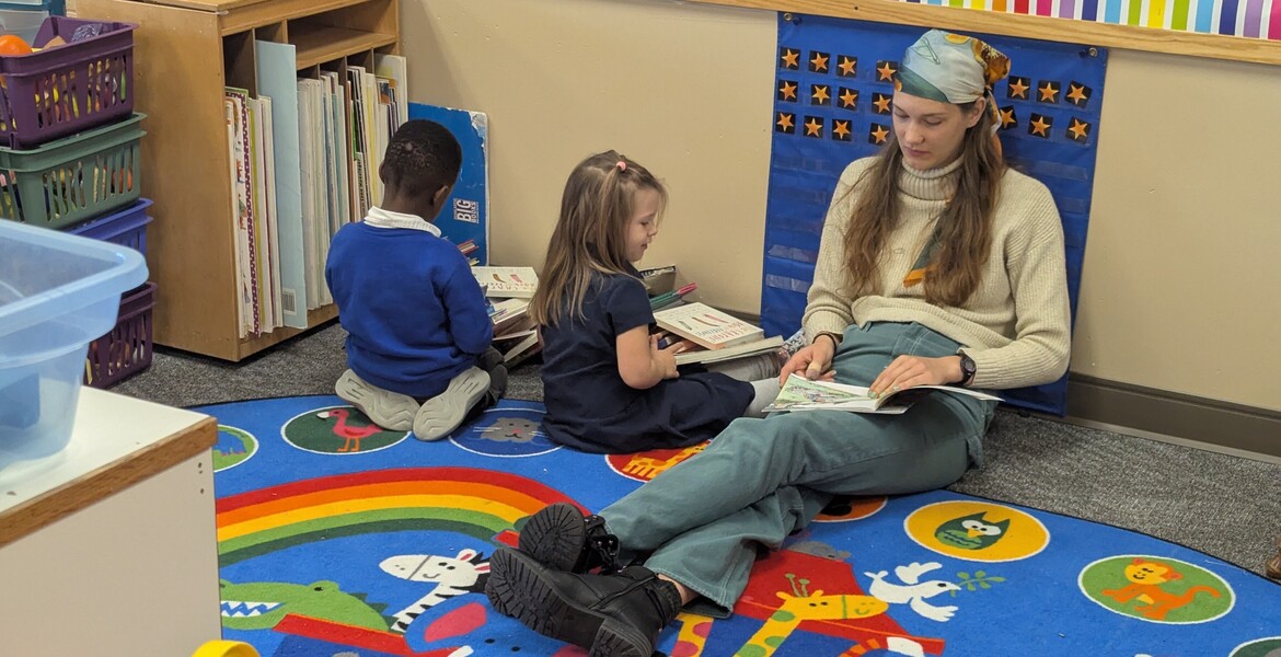 Students reading with the teacher’s aide 